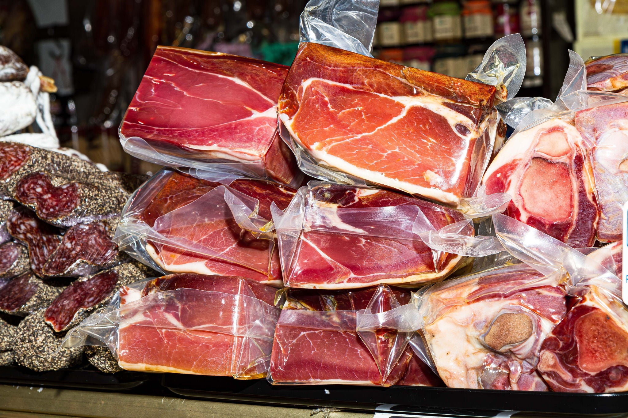 Vacuum packed processed meat products, hamon iberico, prosciutto, salami, sausage, bacon, at food market, Palma, Majorca, Spain.; Shutterstock ID 2433526245; purchase_order: MUDE; job: ; client: Cornelia Geiger; other: 