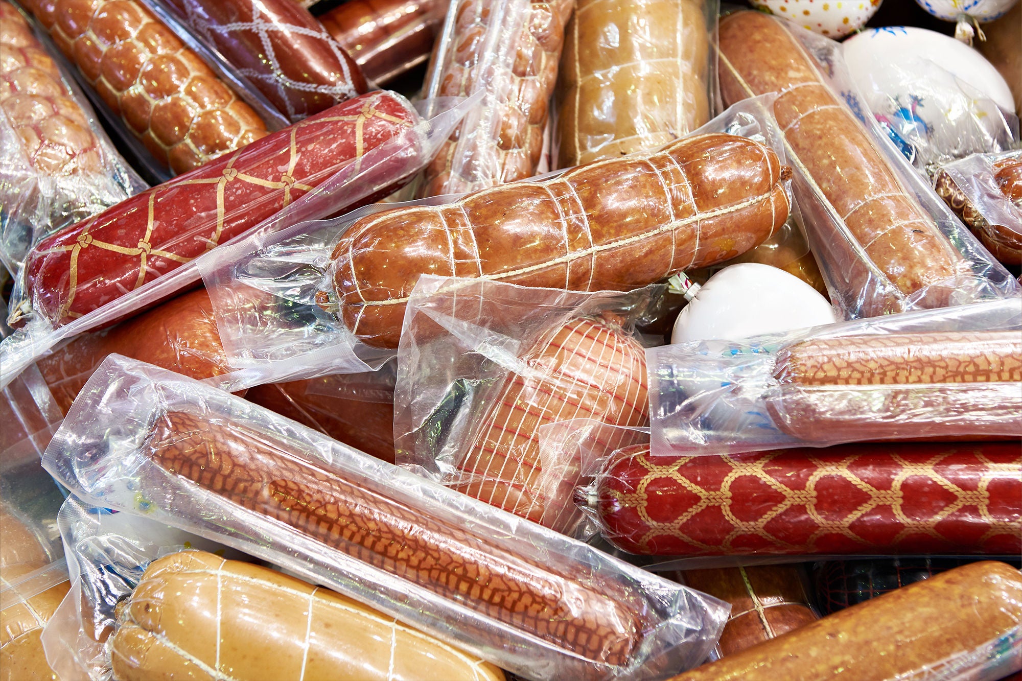 Sausages in vacuum plastic packaging isolated on white background. Vacuum transparent packaging with fresh sausages. A pack of sausages in a vacuum foil isolated.; Shutterstock ID 2460897705; purchase_order: MUDE; job: Landingpage Handwerk; client: Cornelia Geiger; other: 